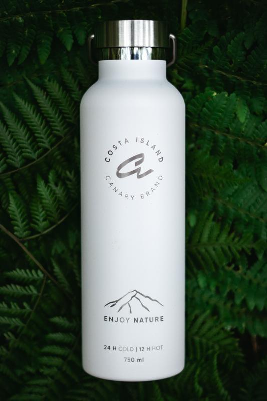 fotografía de producto botella blanca de canary brand sobre fondo de hojas verdes