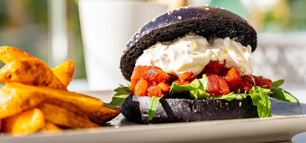 fotografía gastronómica hamburguesa con pan exótico y relleno vegetariano