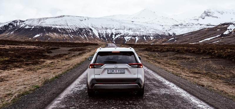 fotografía de expedicion en islandia un coche parado en una carretera con una montaña nevada de fondo
